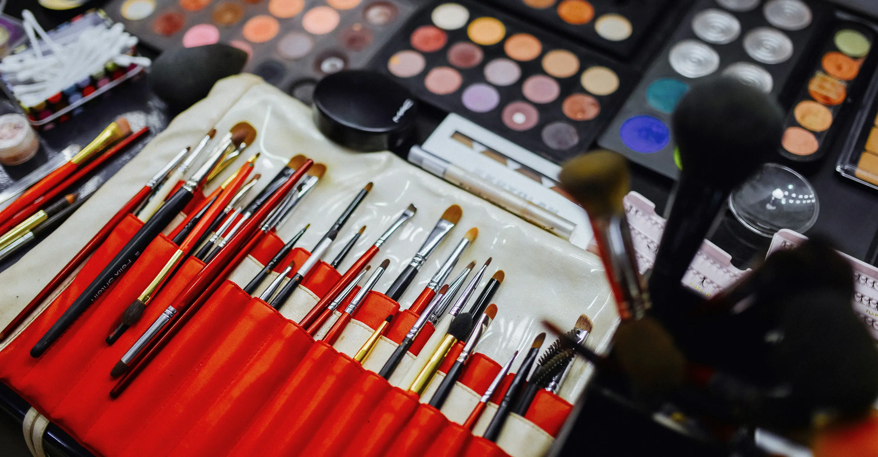 Close-up of makeup brushes and palettes, artistic, detailed, vibrant.