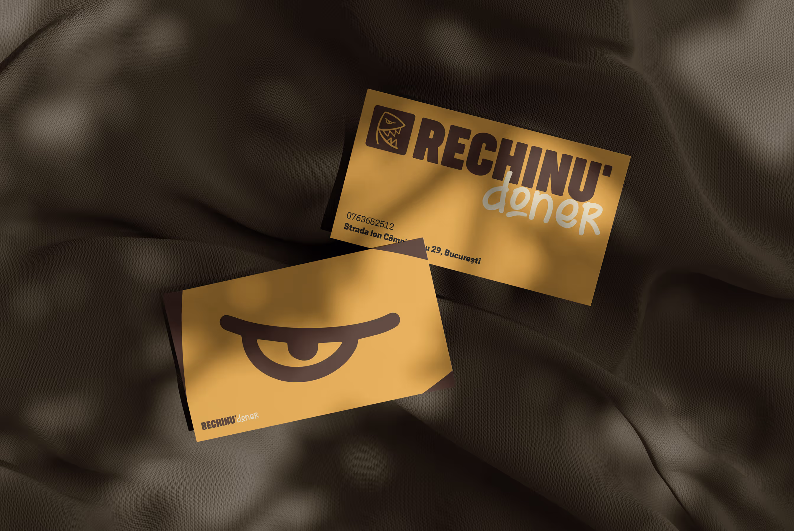Business cards for Rechinu Doner on a textured background, graphic design.