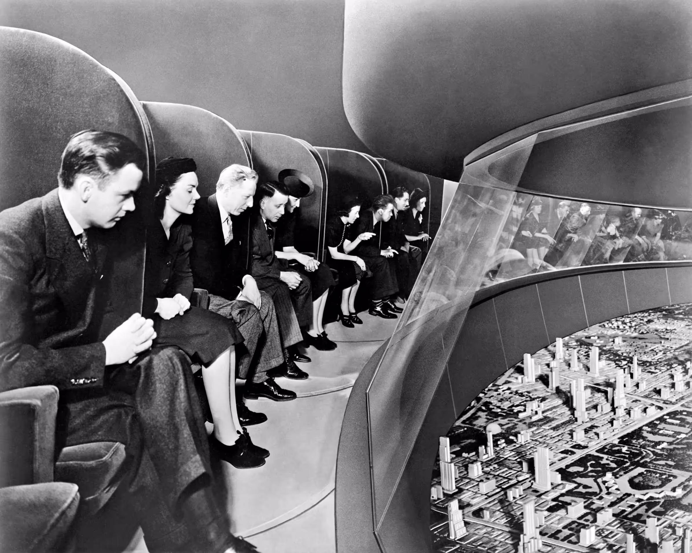 Vintage black and white photo of people viewing a futuristic city model.