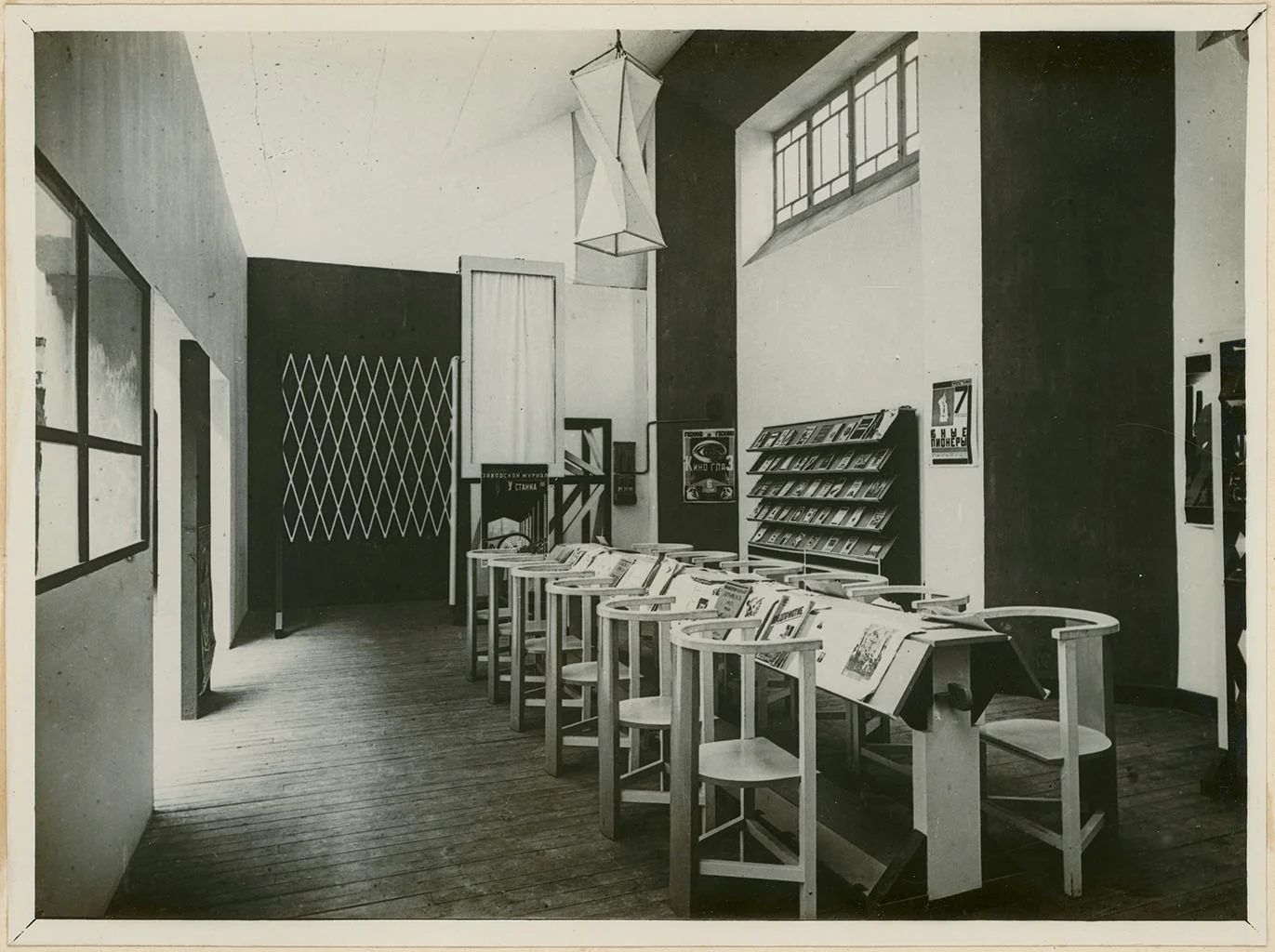 Avant-garde exhibition space with unique circular reading tables and modernist shelving.