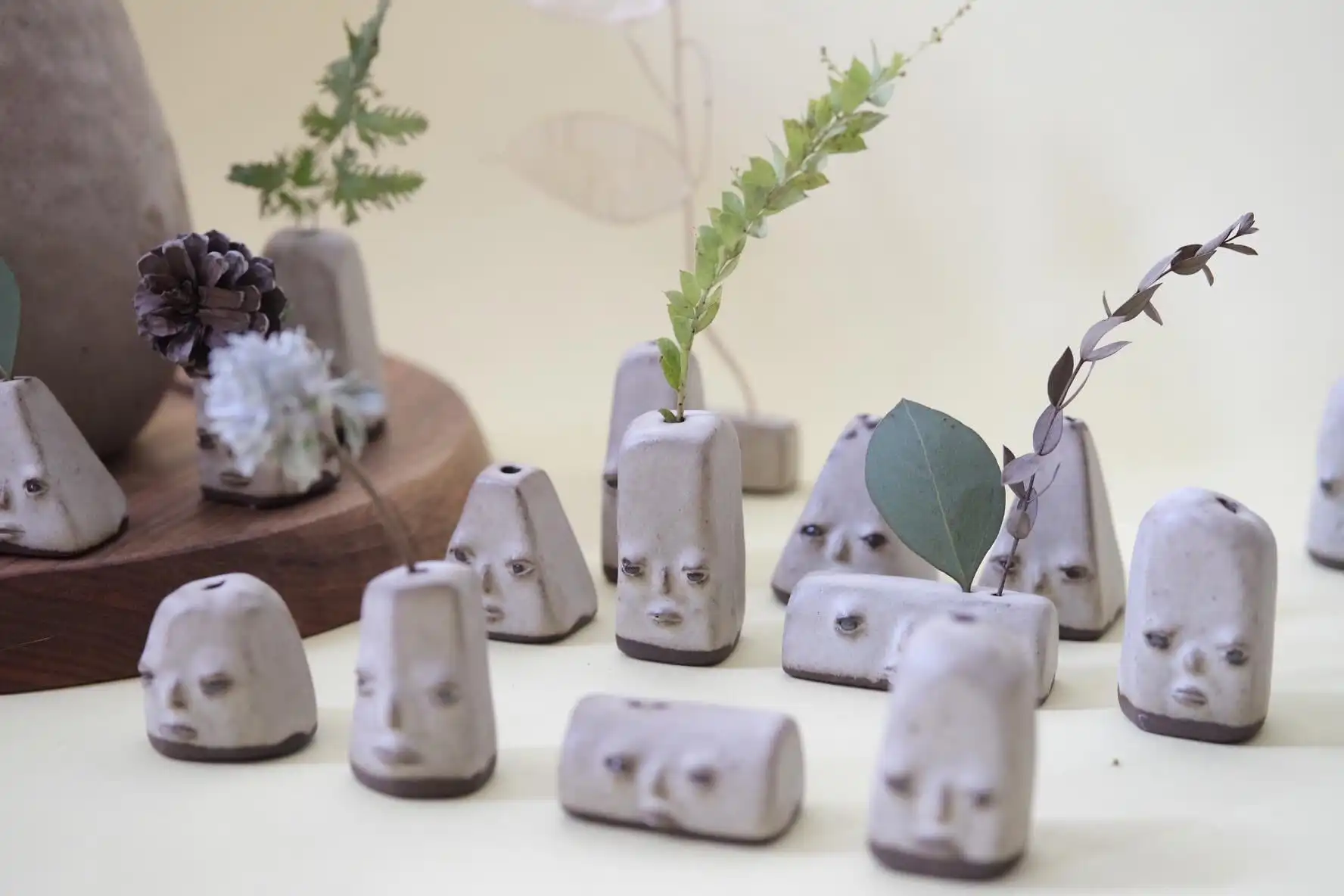 Whimsical ceramic vases with faces, handmade, quirky, artistic display.
