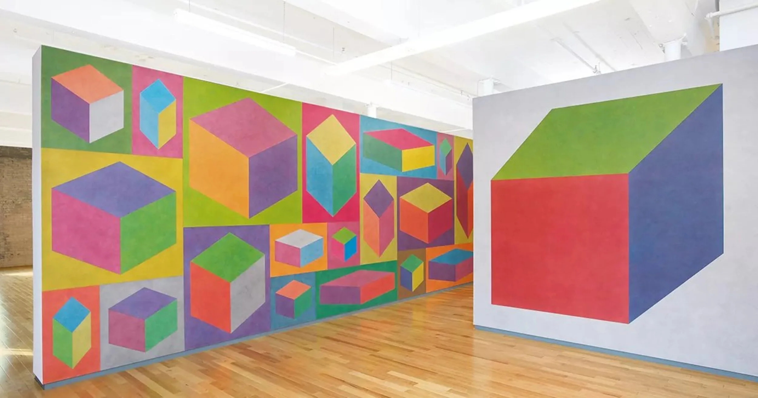 Geometric abstract paintings of colorful cubes on gallery walls.