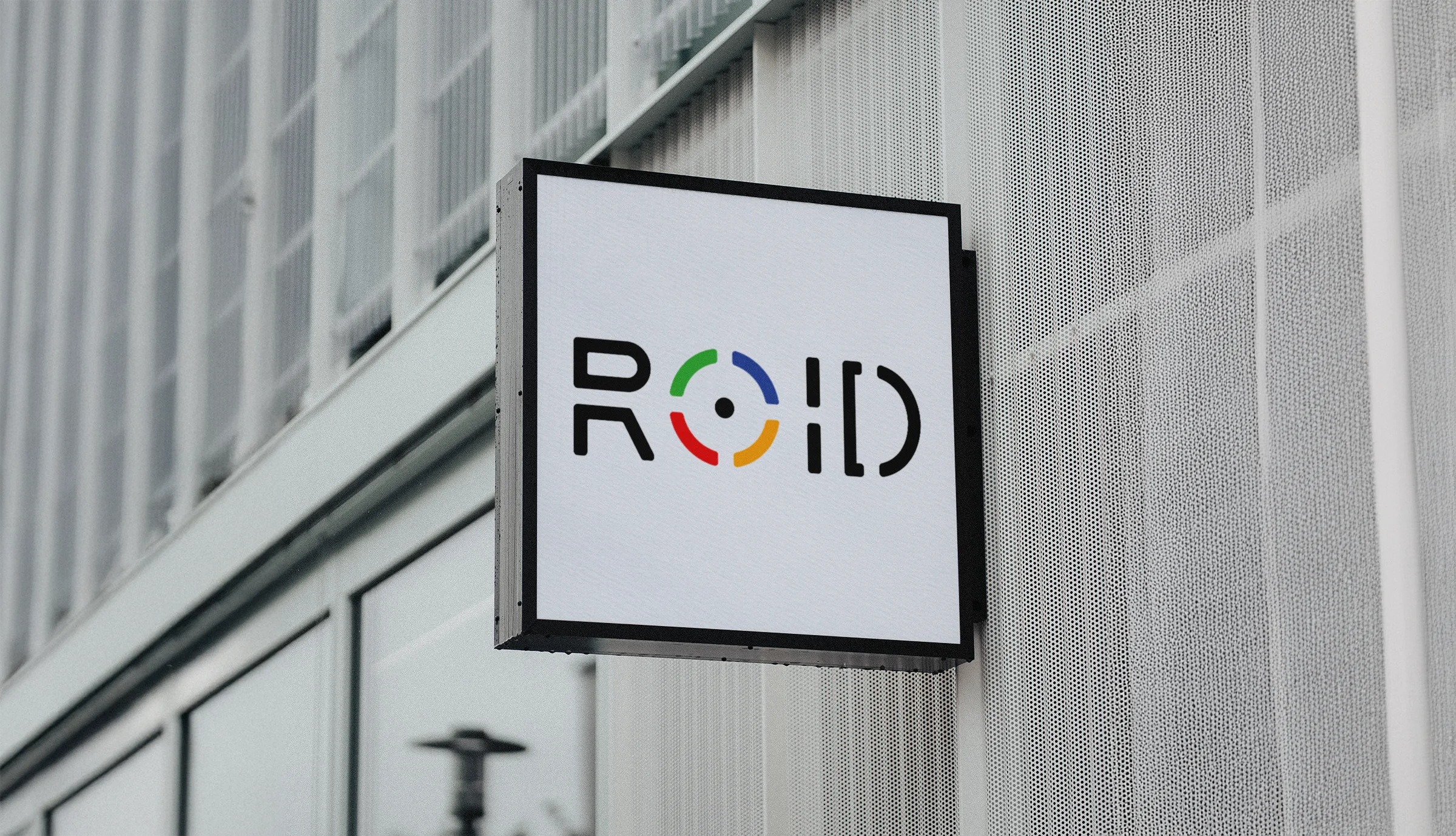 Modern logo sign for ROID on a textured building facade.
