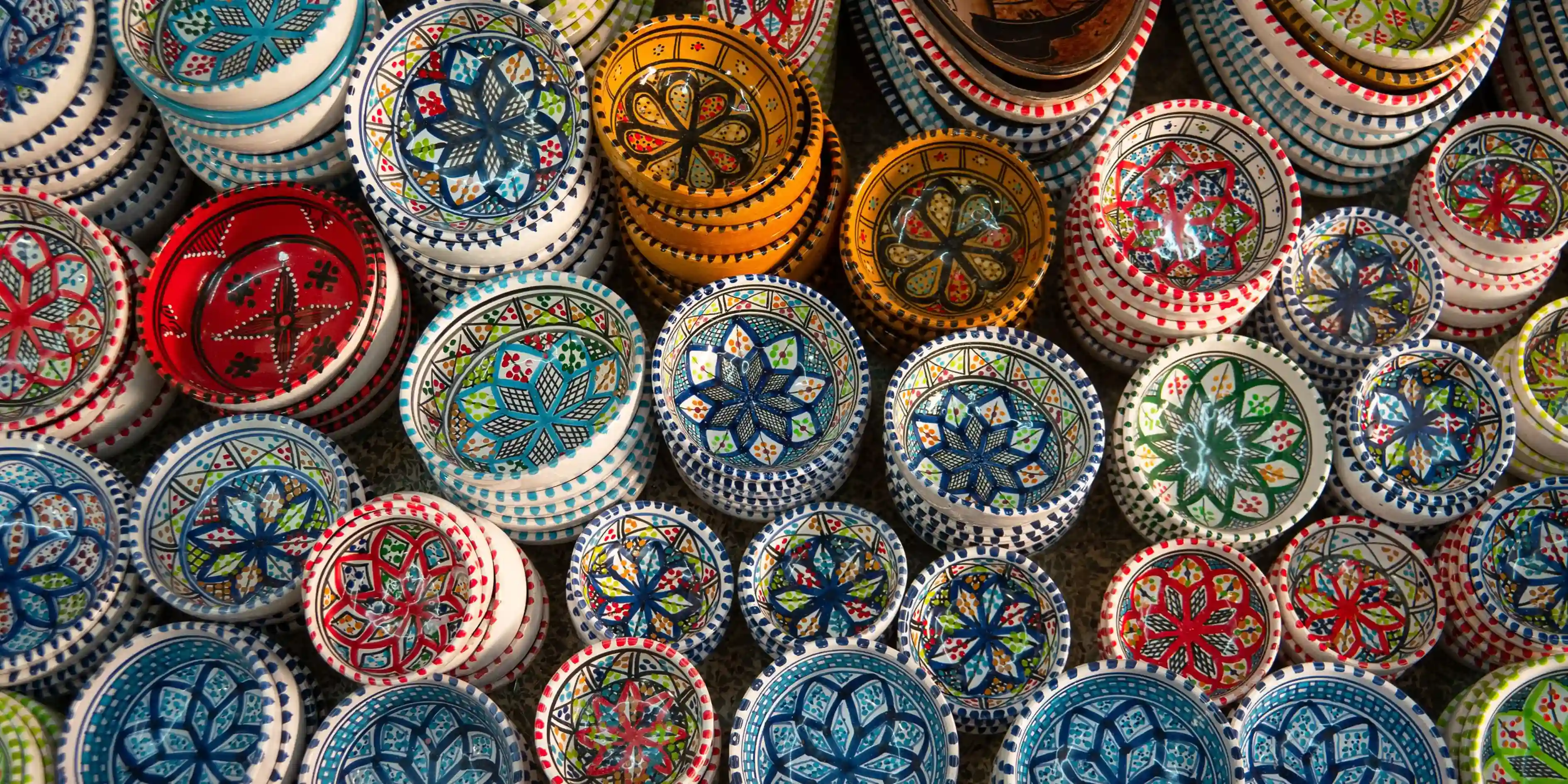 Colorful hand-painted ceramic bowls with intricate geometric patterns.